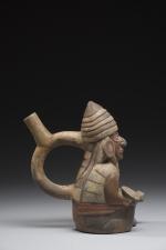 Vase étrier représentant un guerrier agenouillé portant son bouclier rond...